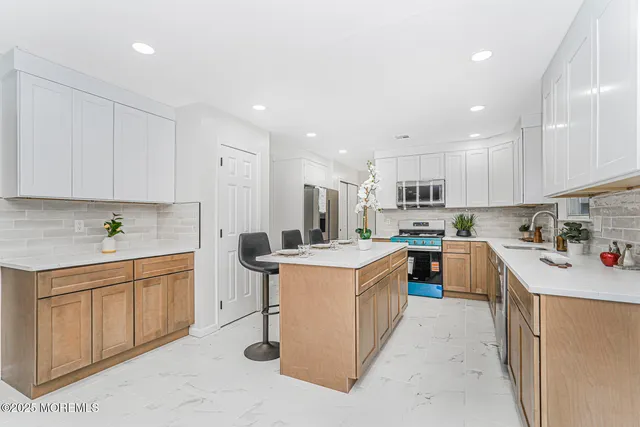 a kitchen with a sink a counter top space stainless steel appliances and cabinets