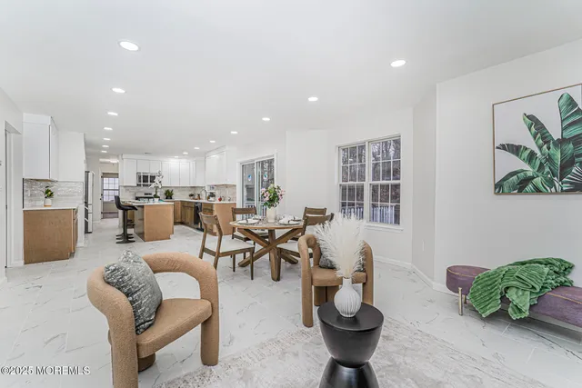 a living room with furniture kitchen view and a potted plant