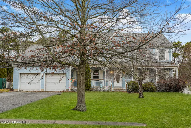 a white house that has a tree in front of it
