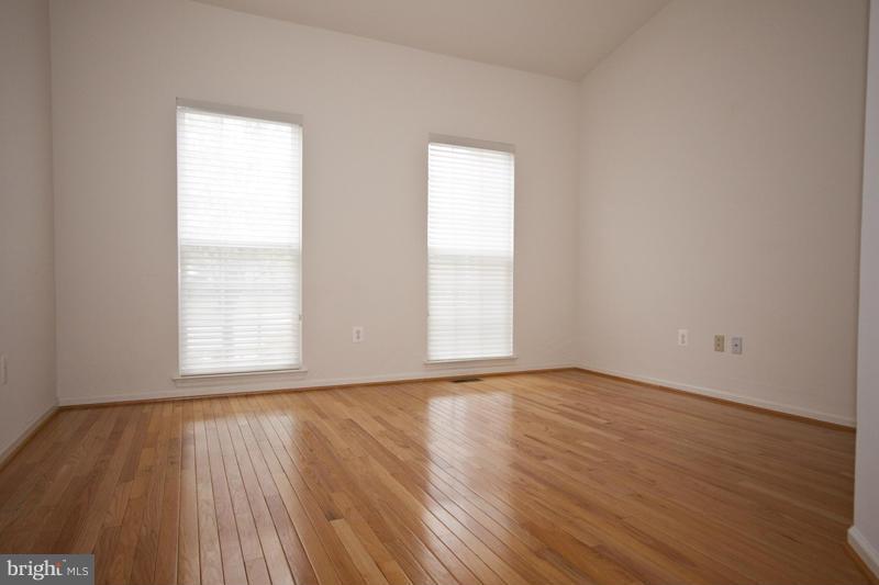 8603 Snowreath Road, Unit 8603 Baltimore, MD 21208 - Photo 12 of 30 a view of an empty room with wooden floor and a window