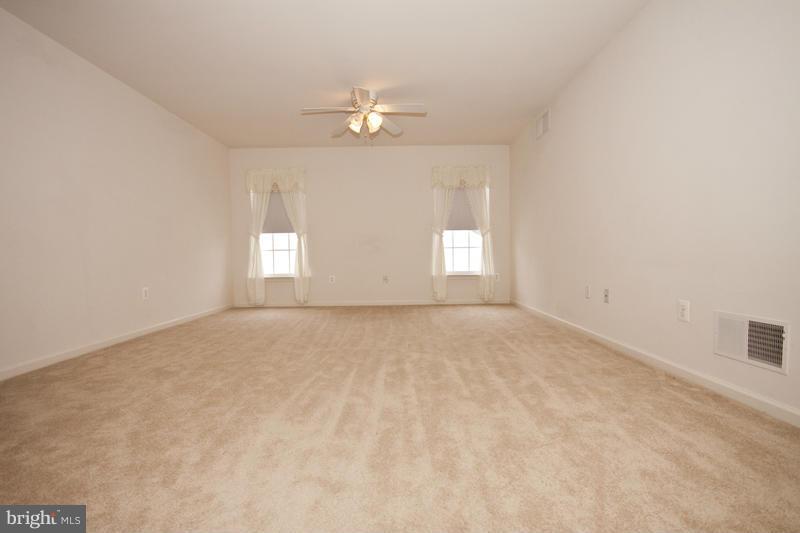 8603 Snowreath Road, Unit 8603 Baltimore, MD 21208 - Photo 28 of 30 en empty room with windows and chandelier fan