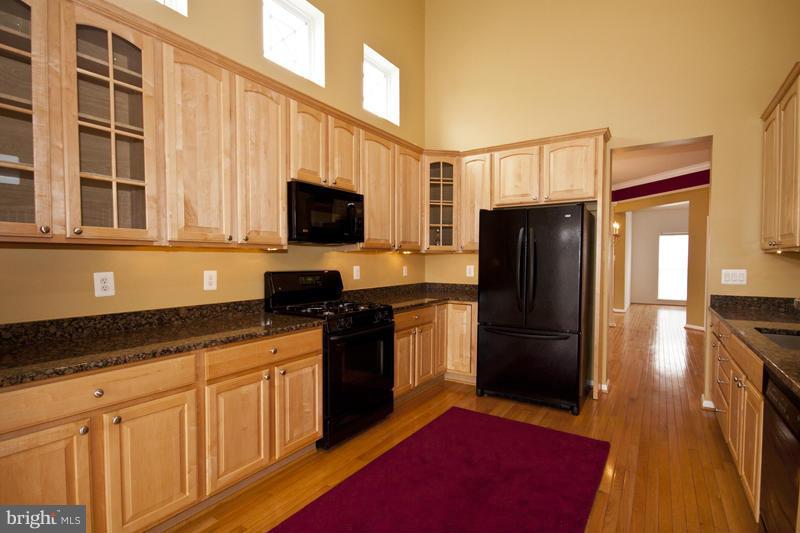 8603 Snowreath Road, Unit 8603 Baltimore, MD 21208 - Photo 7 of 30 a kitchen with granite countertop a refrigerator stove and microwave