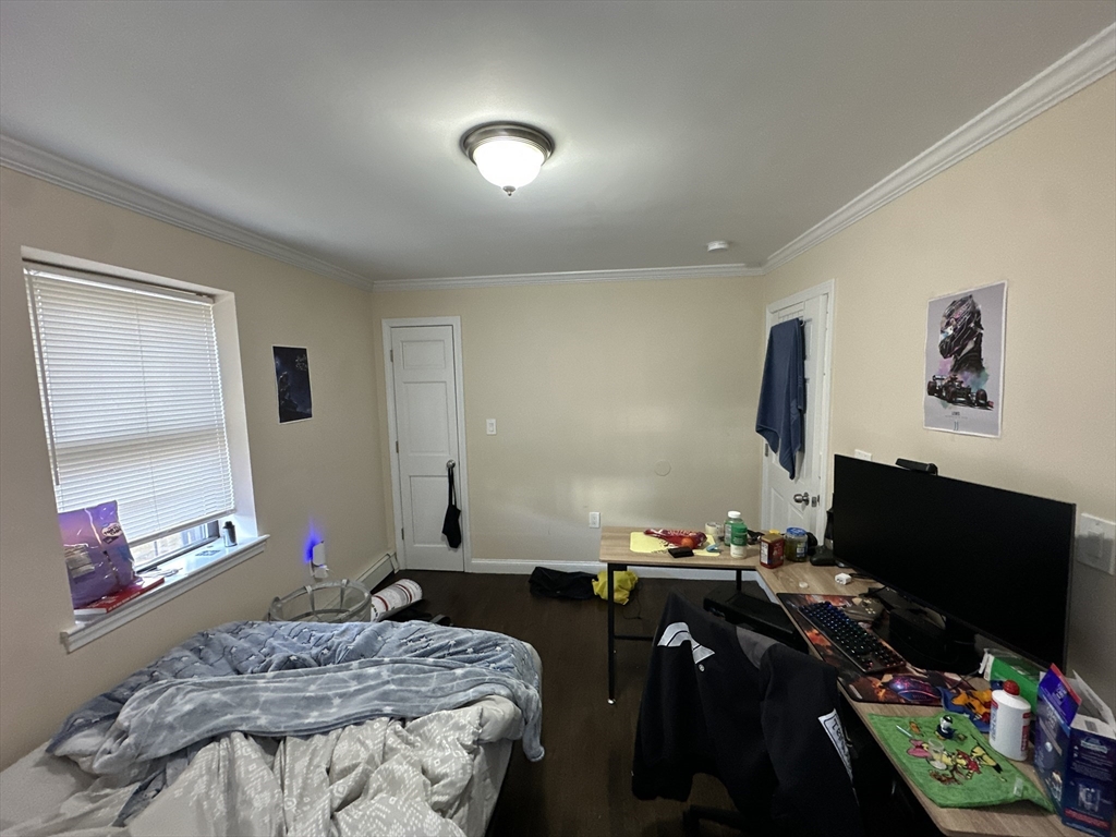 435 Walnut Avenue, Unit A Boston, MA 02119 - Photo 11 of 12 a bedroom with a bed and a flat screen tv