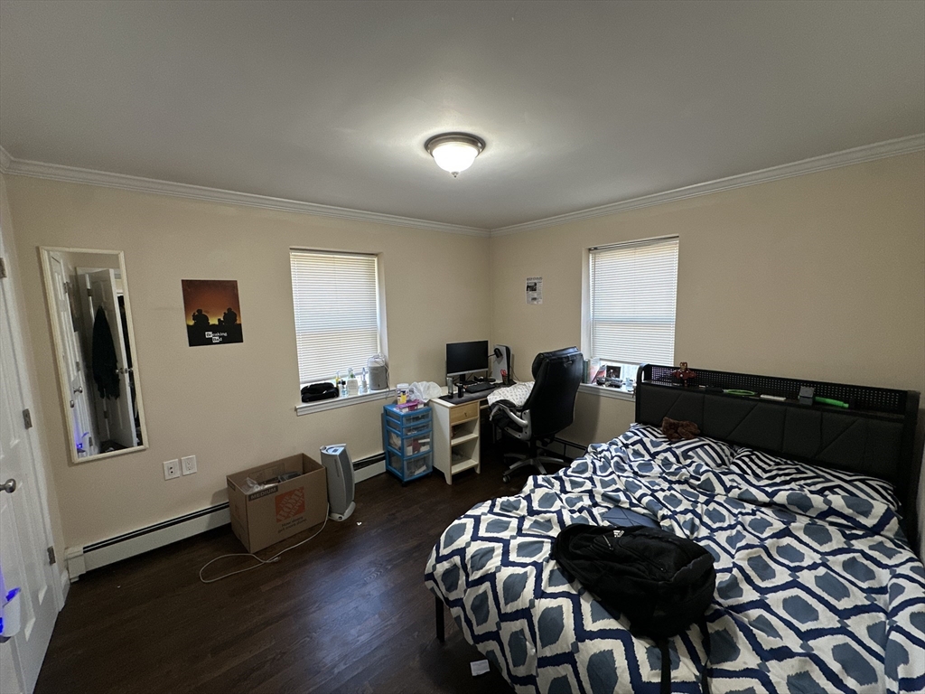435 Walnut Avenue, Unit A Boston, MA 02119 - Photo 3 of 12 a bedroom with a bed and wooden floor