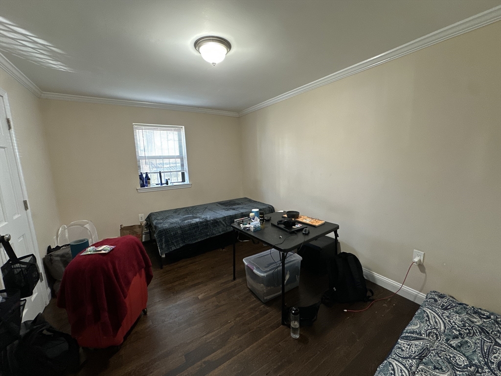 435 Walnut Avenue, Unit A Boston, MA 02119 - Photo 7 of 12 a bedroom with a bed and a window