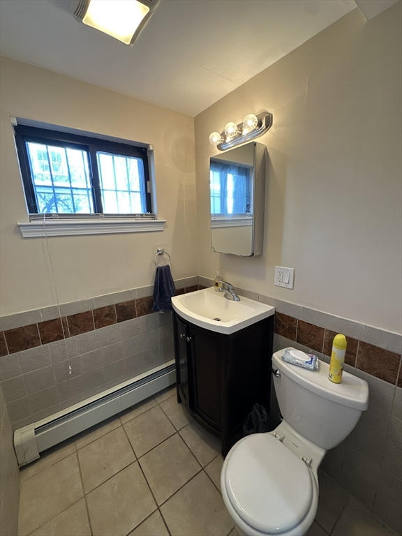 435 Walnut Avenue, Unit A Boston, MA 02119 - Photo 9 of 12 a bathroom with a toilet sink and mirror