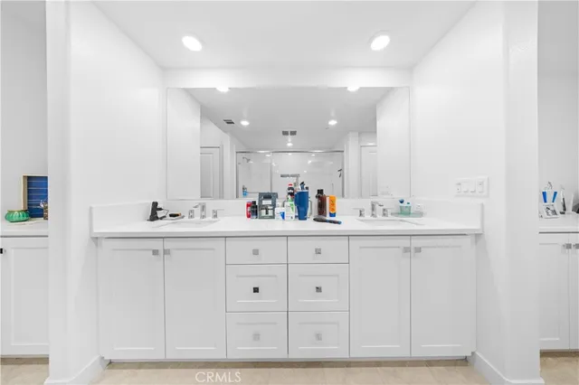 a bathroom with a sink mirror and cabinets