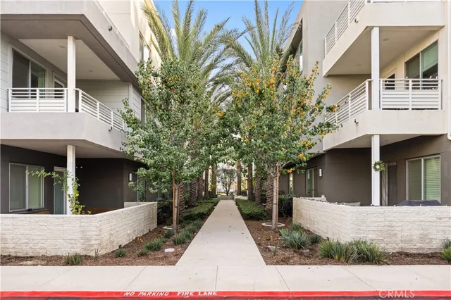 a view of a white house with large windows and a small yard