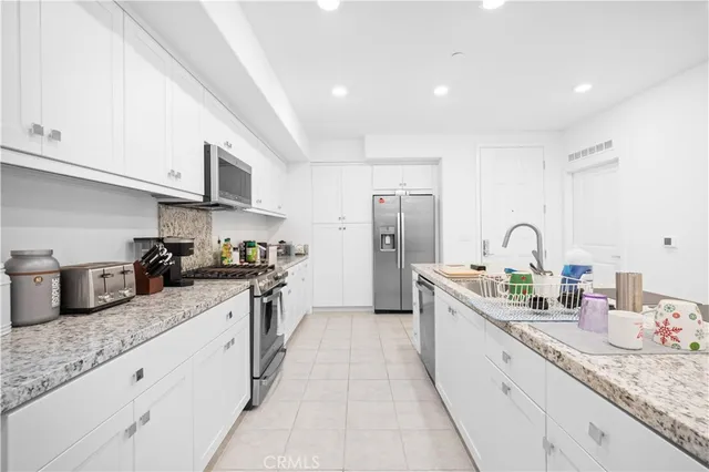 a kitchen with granite countertop a sink stainless steel appliances and cabinets