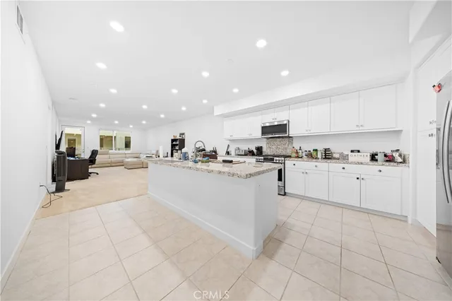 a kitchen with stainless steel appliances granite countertop a refrigerator sink and cabinets