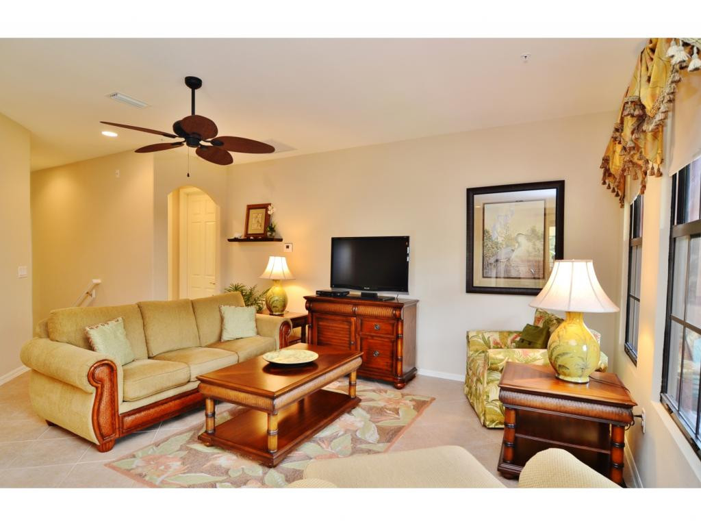 8997 Cambria Circle, Unit 2002 Naples, FL 34113 - Photo 3 of 18 a living room with furniture and a flat screen tv