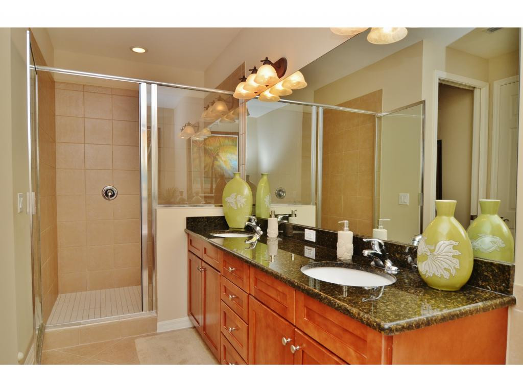 8997 Cambria Circle, Unit 2002 Naples, FL 34113 - Photo 9 of 18 a bathroom with a granite countertop sink and a mirror