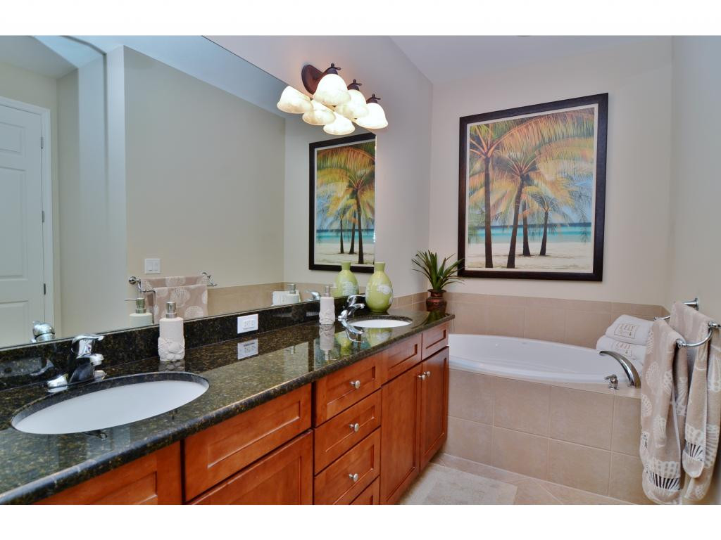 8997 Cambria Circle, Unit 2002 Naples, FL 34113 - Photo 10 of 18 a bathroom with a granite countertop sink and a mirror