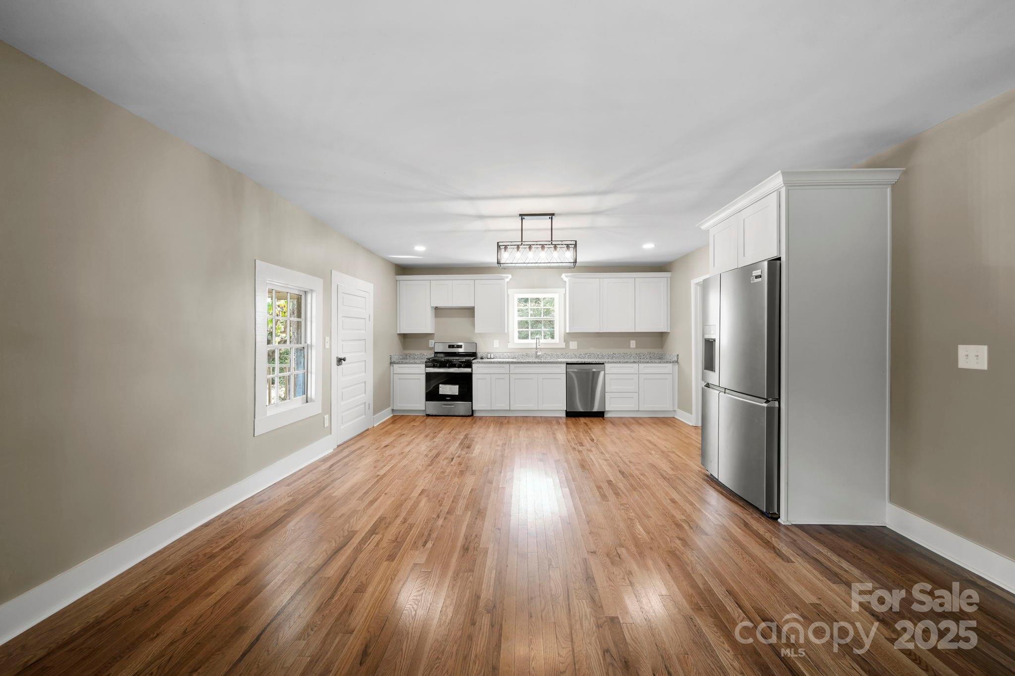 1048 Bowers Road Peachland, NC 28133 - Photo 15 of 44 a large kitchen with a wooden floor and stainless steel appliances
