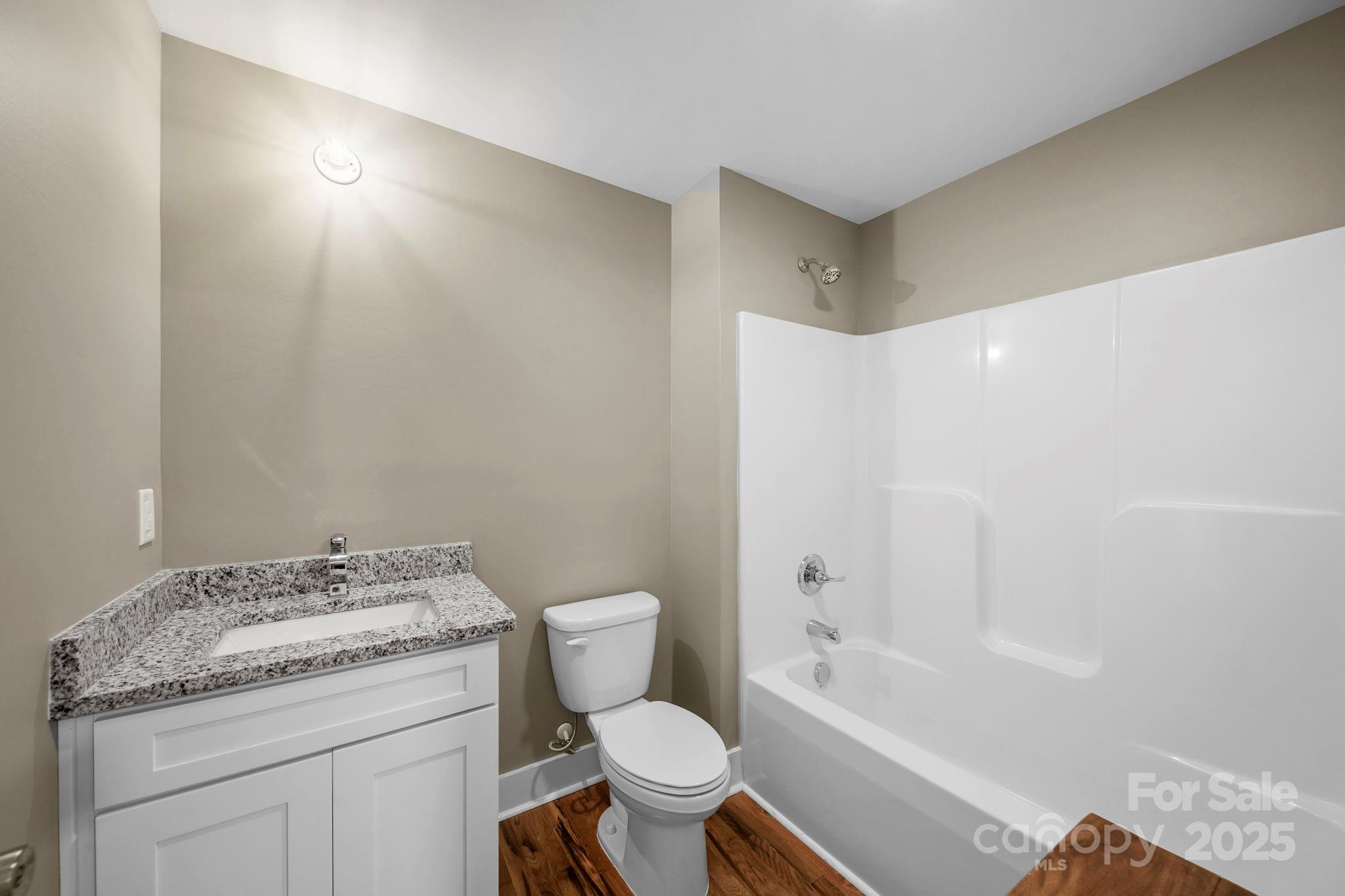 1048 Bowers Road Peachland, NC 28133 - Photo 28 of 44 a bathroom with a granite countertop toilet a sink and a bathtub