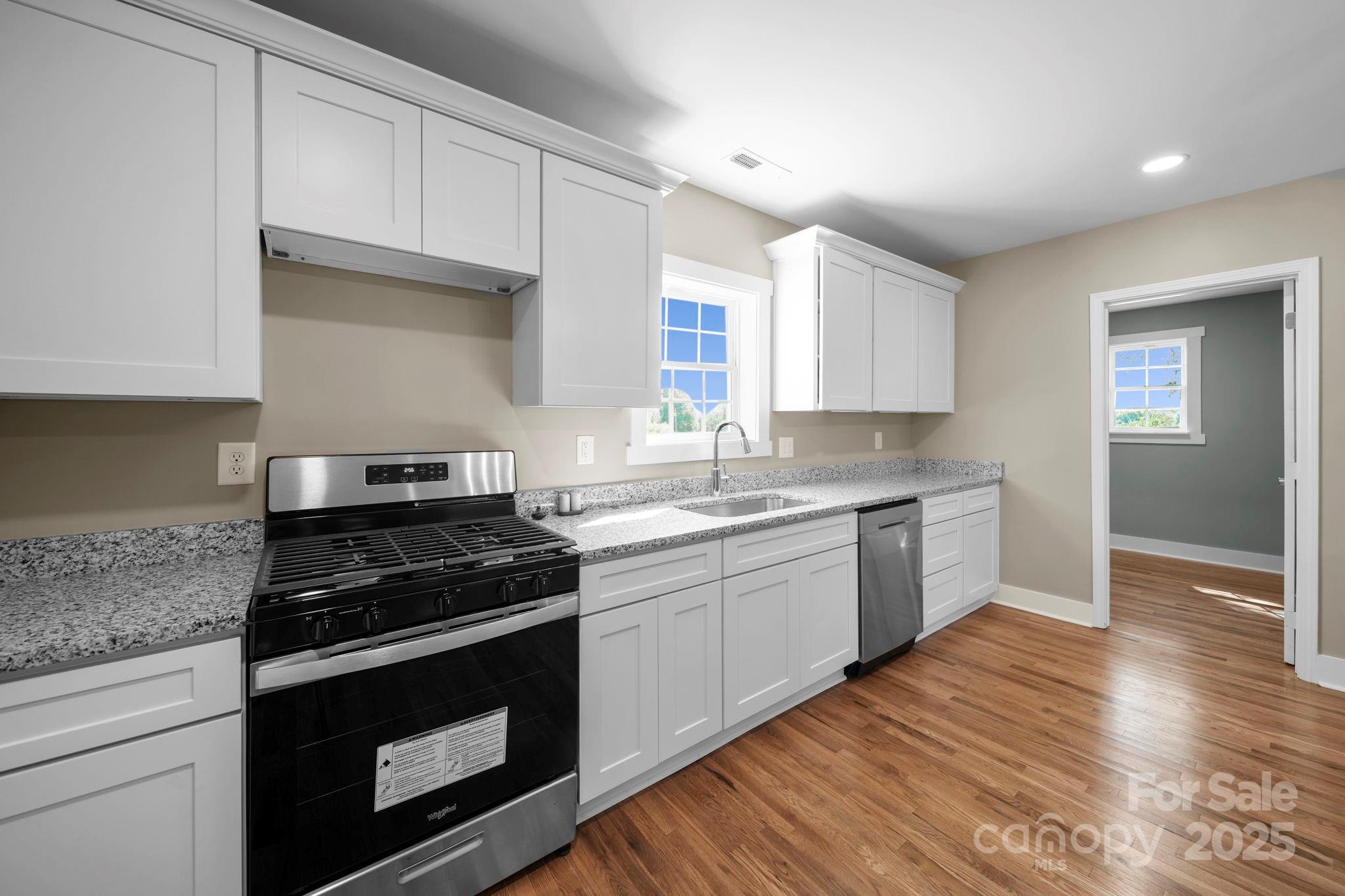 1048 Bowers Road Peachland, NC 28133 - Photo 10 of 44 a kitchen with granite countertop wooden cabinets and a stove top oven