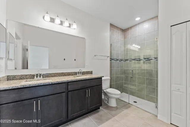 a bathroom with a double vanity sink toilet and shower