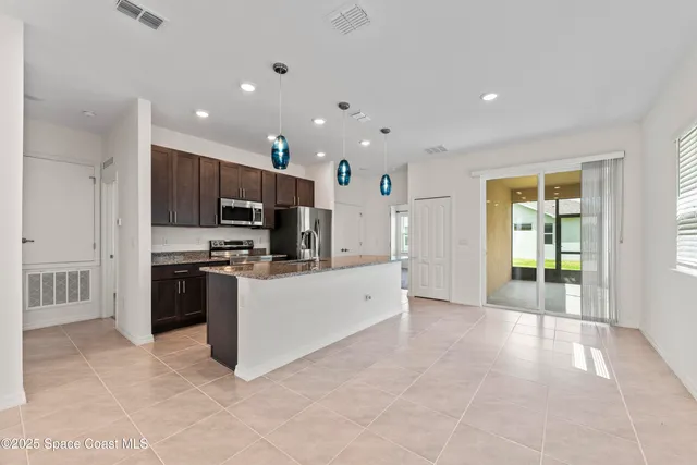 a large white kitchen with a large window and stainless steel appliances