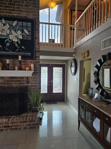 a living room with furniture a fireplace and potted plant