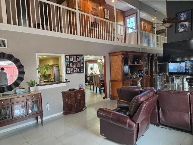 a living room with furniture a flat screen tv and entryway