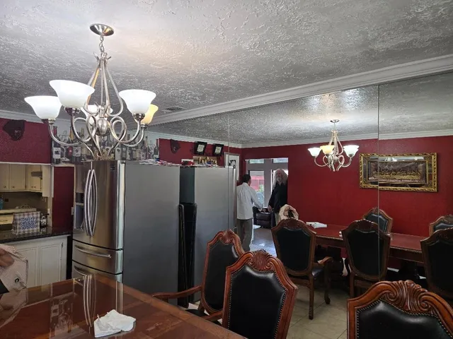 a room with lots of appliances and a chandelier