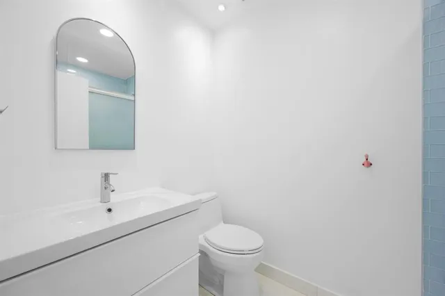 a bathroom with a sink a toilet and mirror
