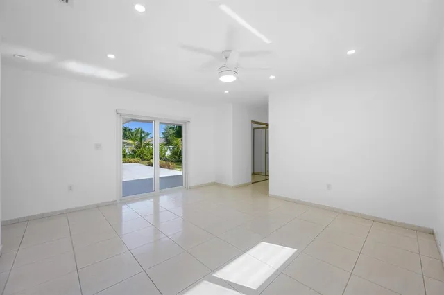 an empty room with a ceiling fan and a window