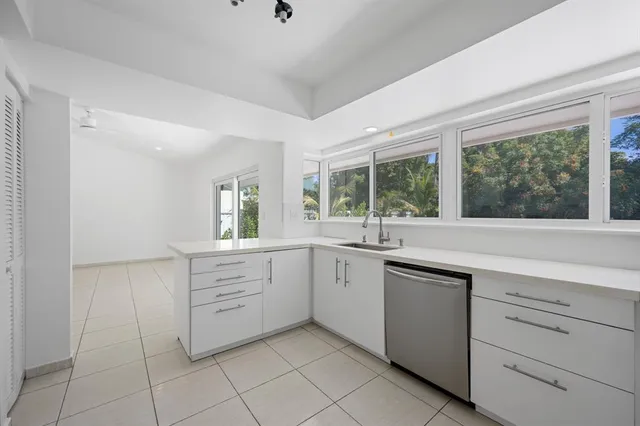 a kitchen with white cabinets and sink