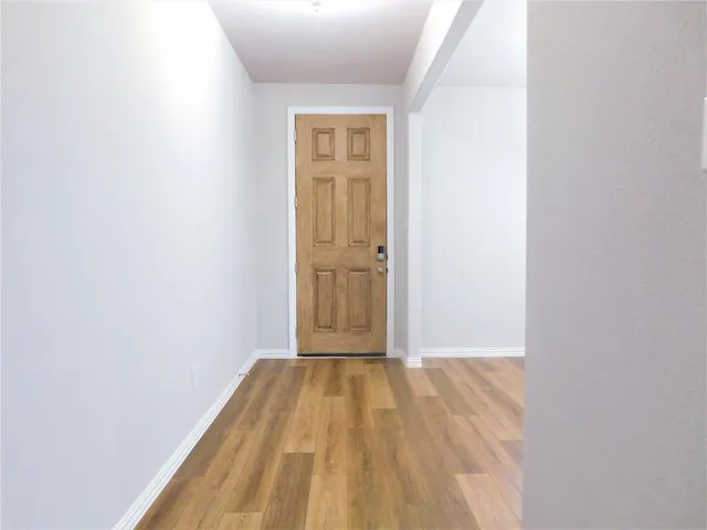 a view of a room with wooden floor and a window