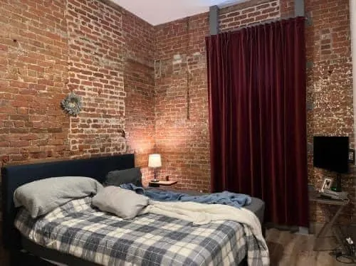 a bedroom with a bed and wooden floor