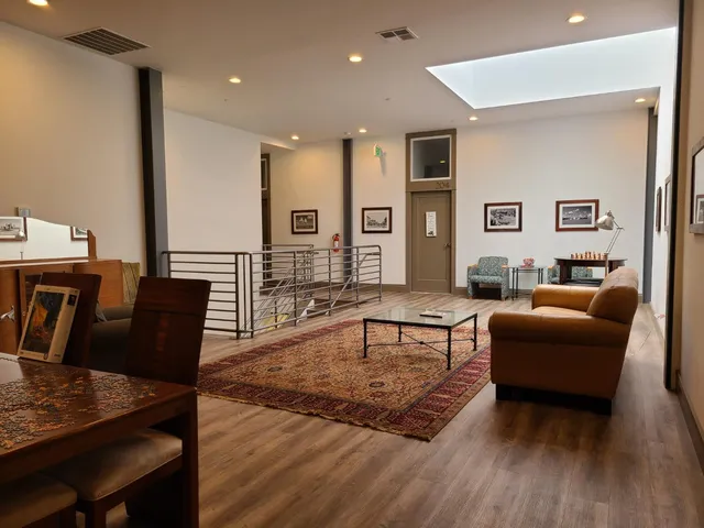 a living room with furniture a large window and a table