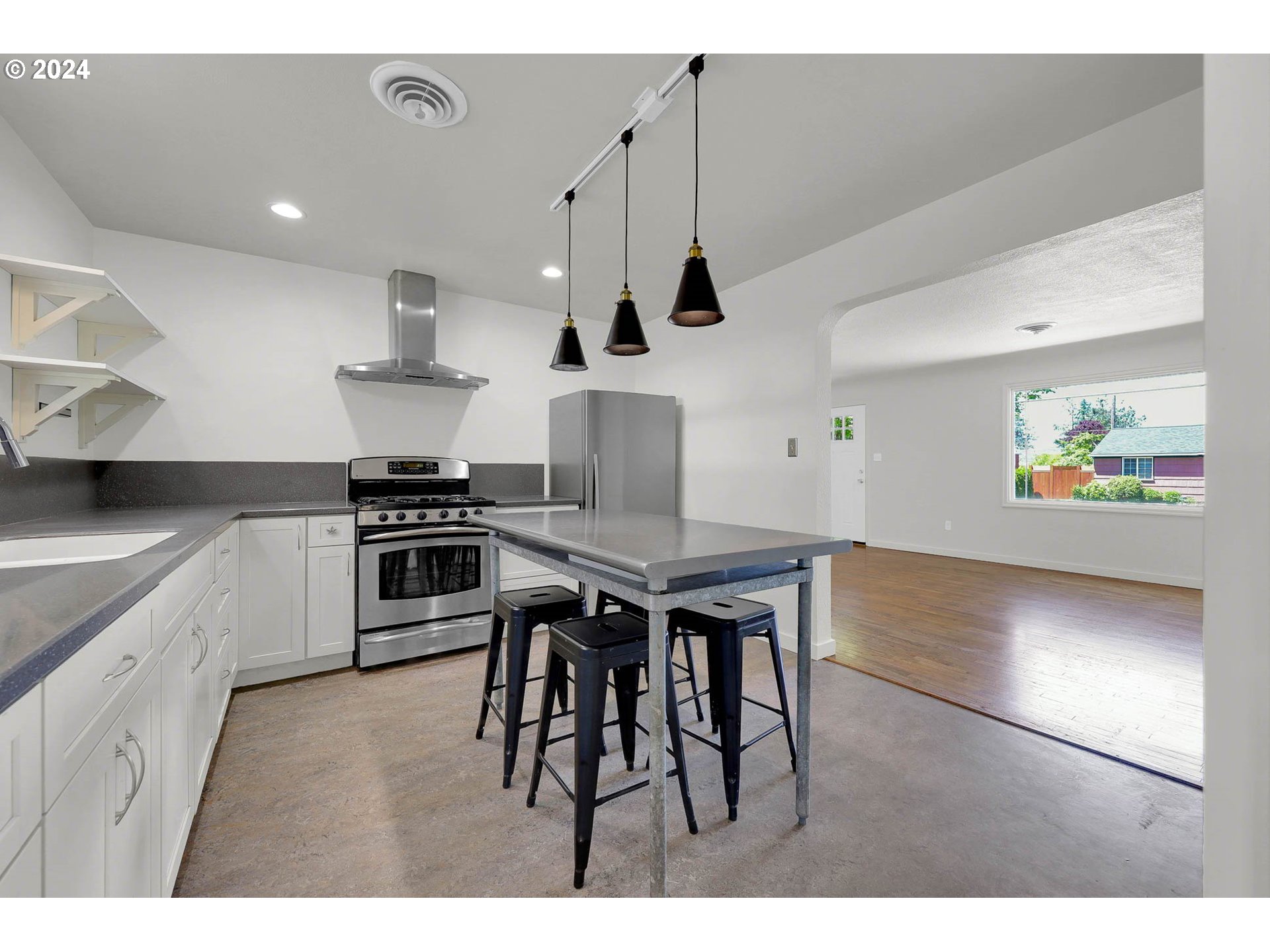 1325 Modoc Street Springfield, OR 97477 - Photo 10 of 36 a kitchen with stainless steel appliances kitchen island a table and chairs in it