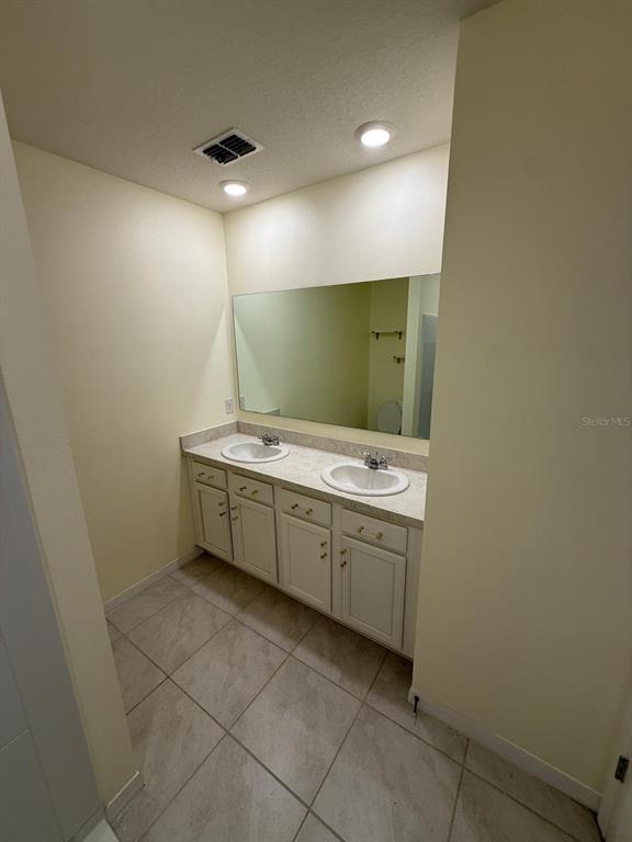2617 Harmonia Hammock Road Harmony, FL 34773 - Photo 11 of 36 a bathroom with a sink a vanity and a mirror