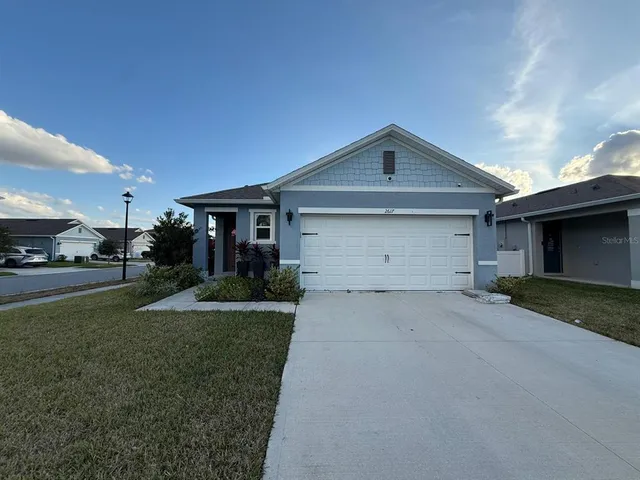 a front view of a house with a yard and garage