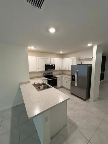 a kitchen with stainless steel appliances granite countertop a refrigerator and a stove