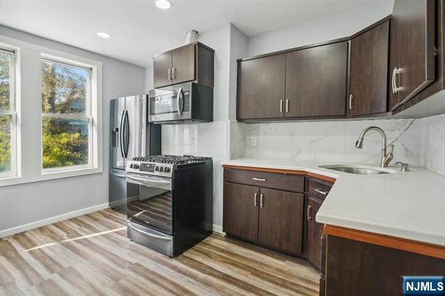 127 Randolph Avenue, Unit 2 Jersey City, NJ 07305 - Photo 2 of 17 a kitchen with stainless steel appliances granite countertop a refrigerator stove and sink