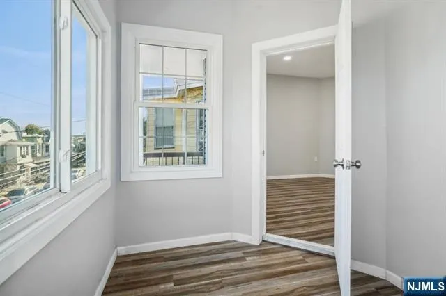 a view of a livingroom with wooden floor and windows