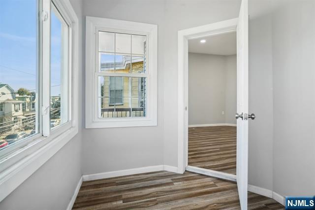 127 Randolph Avenue, Unit 2 Jersey City, NJ 07305 - Photo 8 of 17 a view of a livingroom with wooden floor and windows