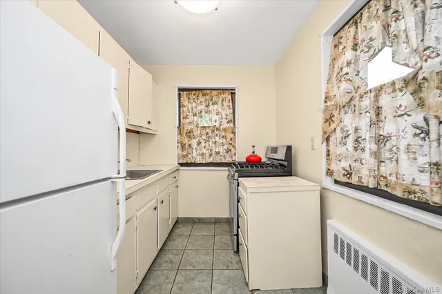 a kitchen with granite countertop white cabinets and white appliances
