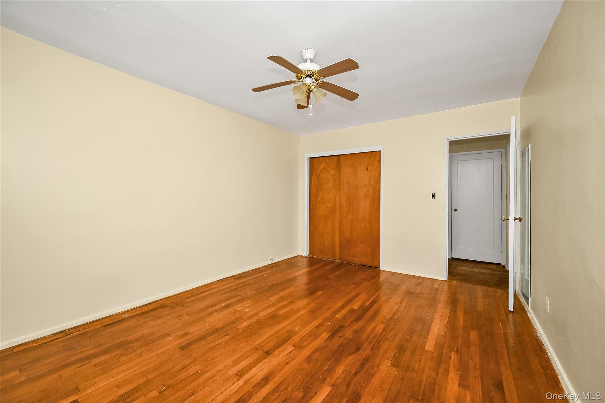 16-01 160th Street, Unit 6279 Queens, NY 11357 - Photo 10 of 17 a view of an empty room with wooden floor and a ceiling fan