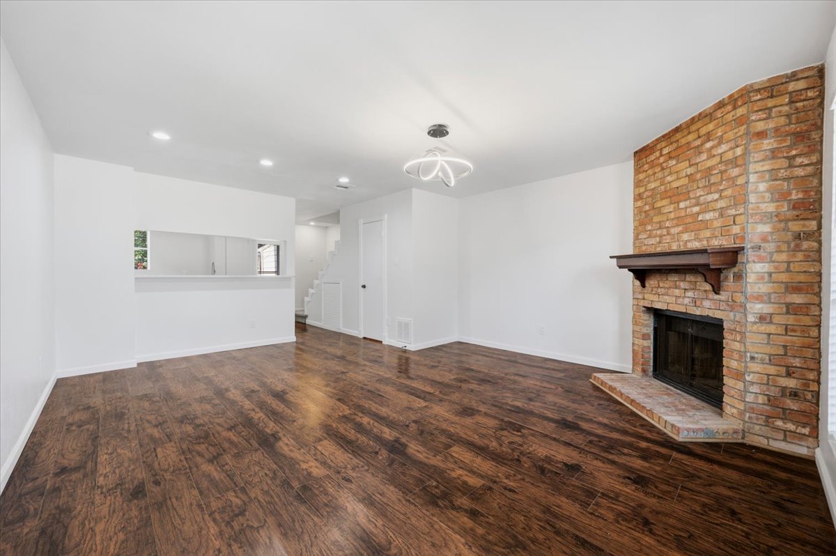 41 Abbey Road Euless, TX 76039 - Photo 6 of 23 Rich wood flooring anchors this living space accented by a corner brick fireplace.