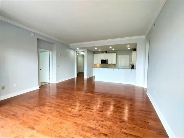 a view of empty room with wooden floor