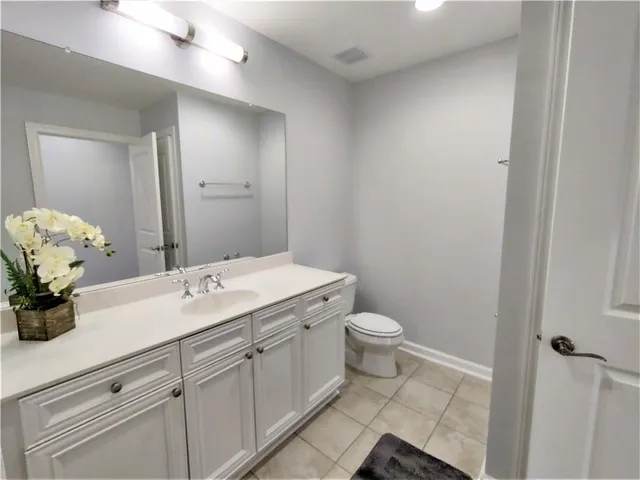 a bathroom with a granite countertop sink a toilet and a mirror