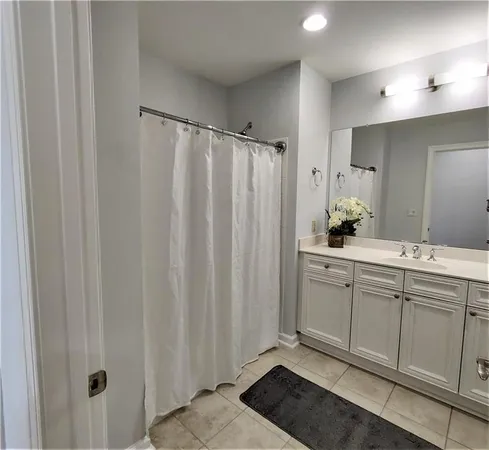 a bathroom with a granite countertop sink a mirror and a shower