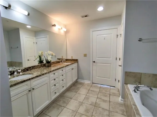 a spacious bathroom with a granite countertop sink a mirror and a