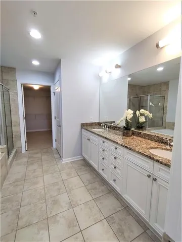 a bathroom with a granite countertop sink a mirror and a shower