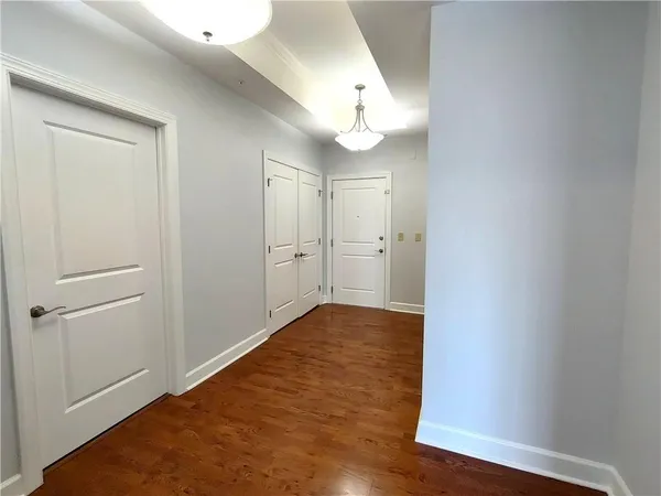 a view of a big room with wooden floor and windows
