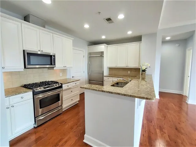 a kitchen with granite countertop stainless steel appliances and wooden cabinets