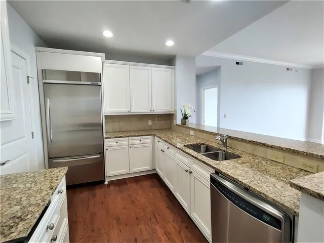 a kitchen with granite countertop a sink stove and refrigerator