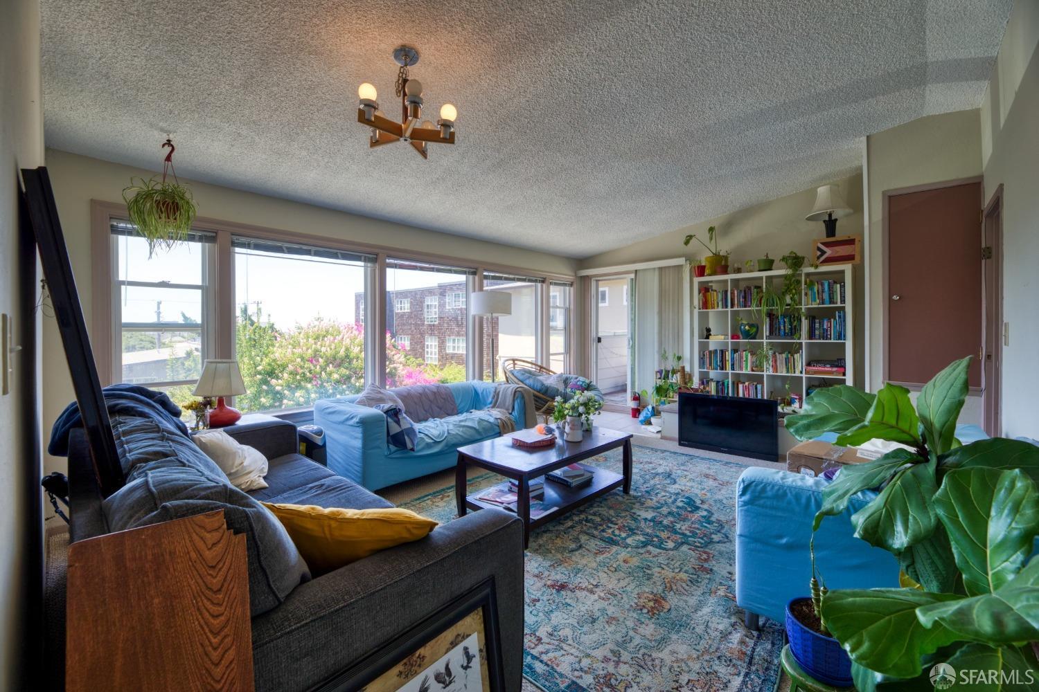 1334-1336 Walnut Street Berkeley, CA 94709 - Photo 8 of 18 a living room with furniture potted plant floor to ceiling window and a flat screen tv